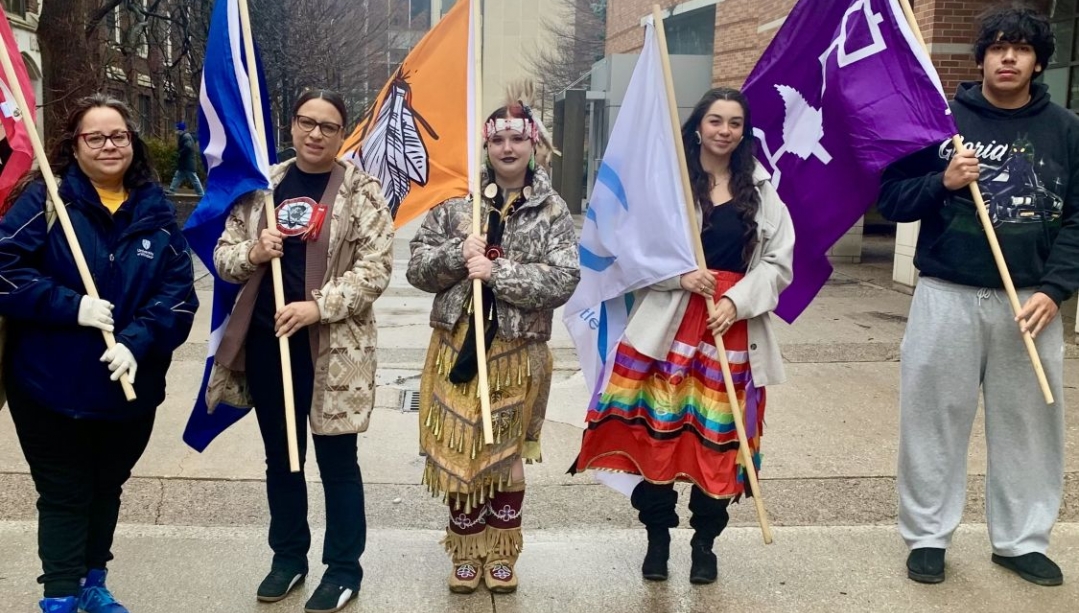 Staff and students holding flags of Indigenous nations