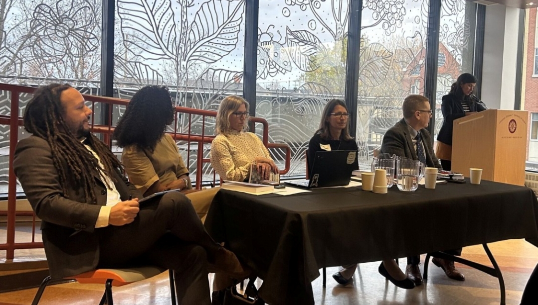 Joshua Sealy-Harrington sits with his colleagues at the book launch.