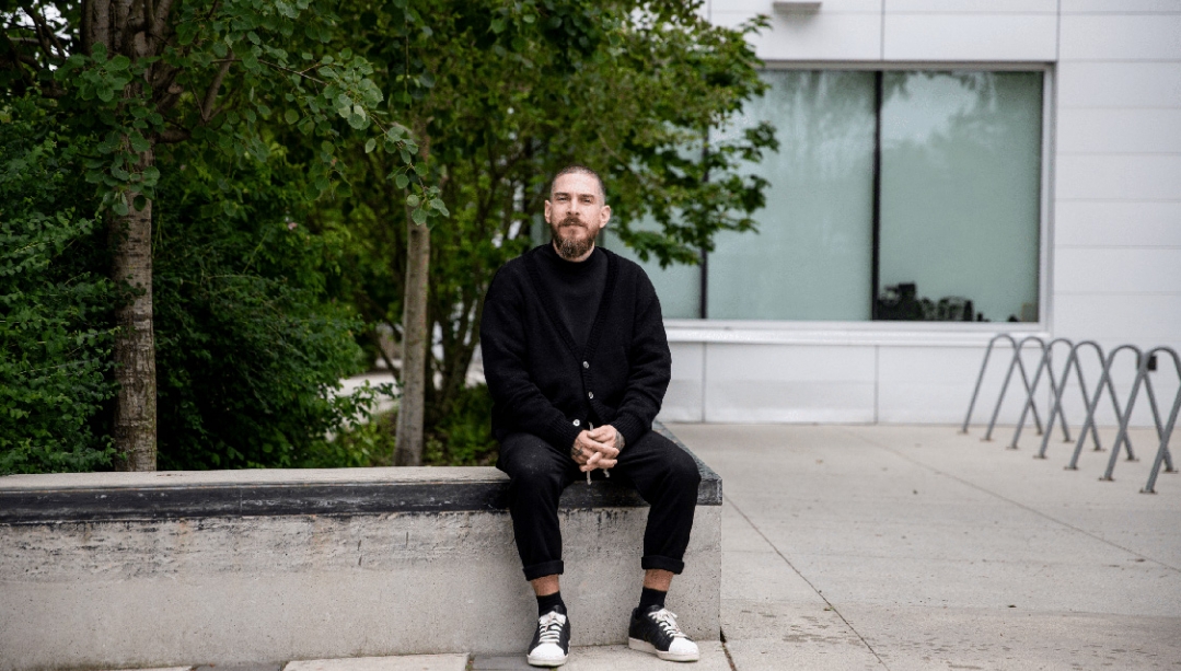 portrait of Justin Langlois seating in front of a building