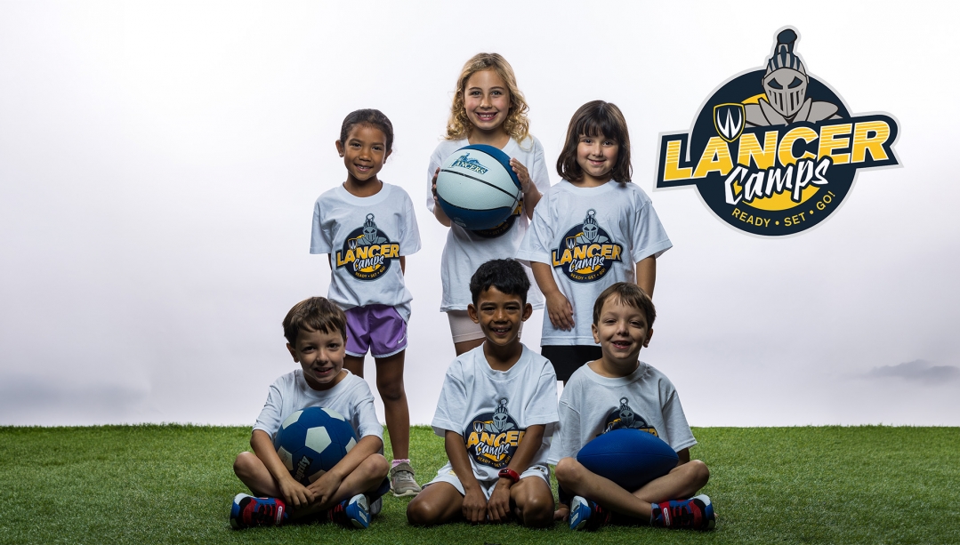 Children posing with lancer Camp t-shirts.