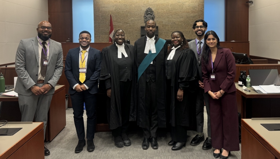 students and judges pose in the courtroom after a moot competition
