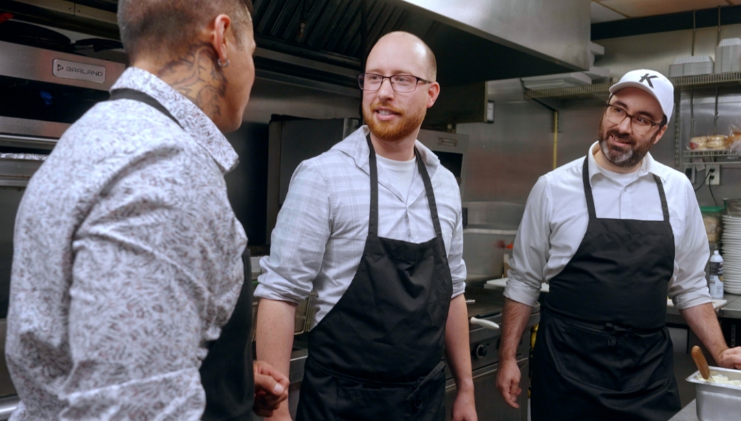 Producers and restaurant staff in a kitchen.