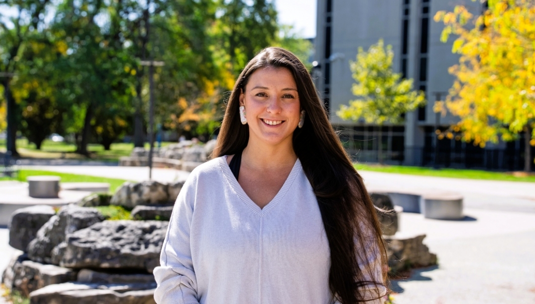 Professor Sara Williams stands outside on campus on a sunny day