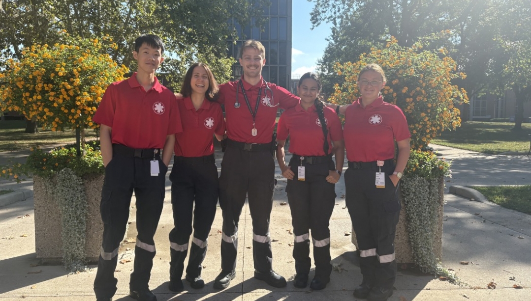 Student volunteers stand outside on campus wearing their SMRS uniforms