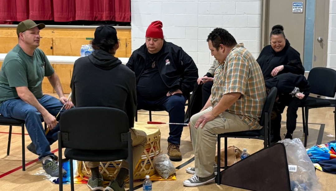 Members of Aamjiwnaang community gather around a traditional drum