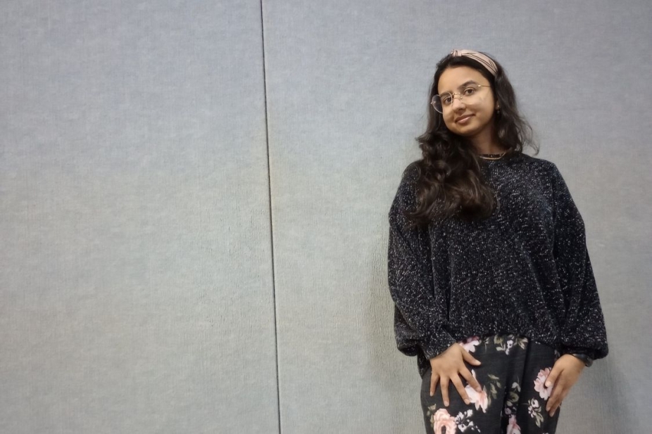 Samita Sarkar in front of a grey background wearing heart shaped glasses