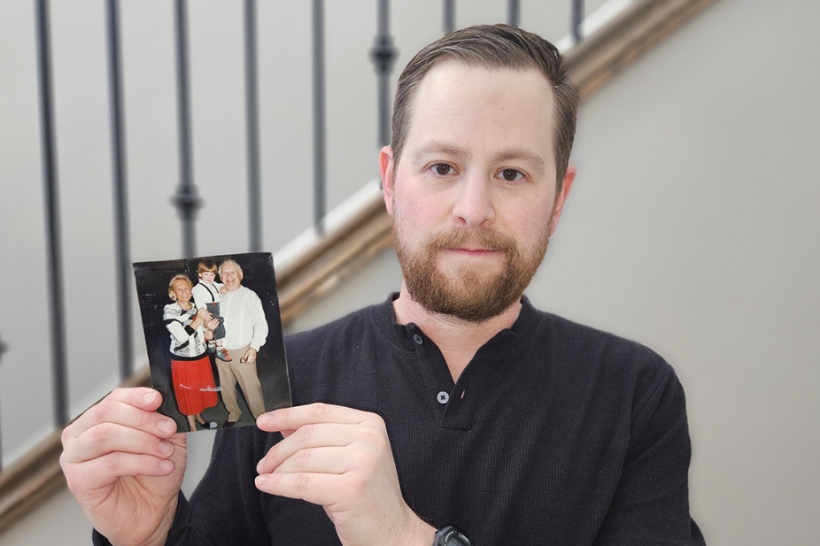 Dr. Kyle Brykman holds up a picture of his grandparents cradling him as a young boy