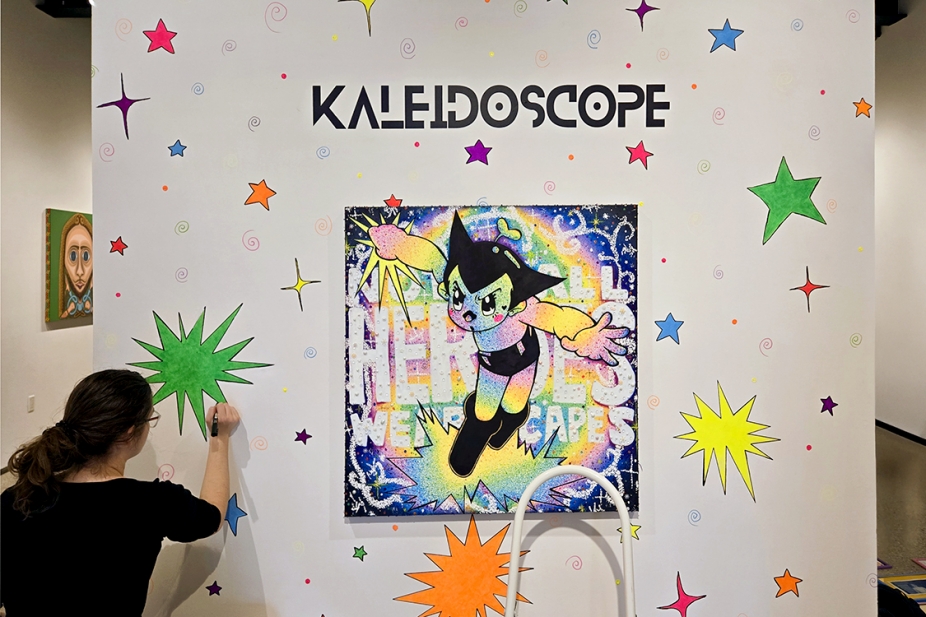 image of student painting graphics on gallery entrance wall