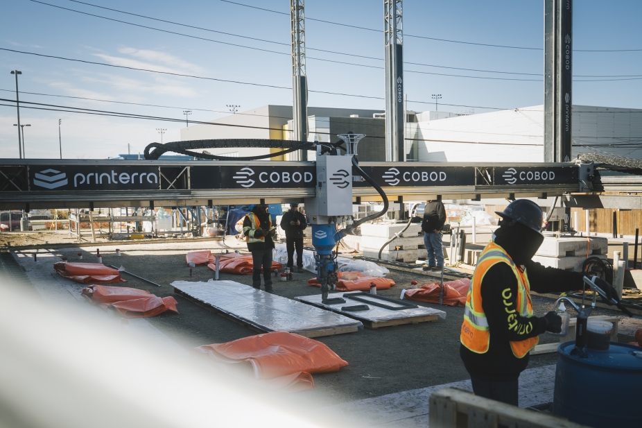 Construction workers onsite preparing the 3D printer to build