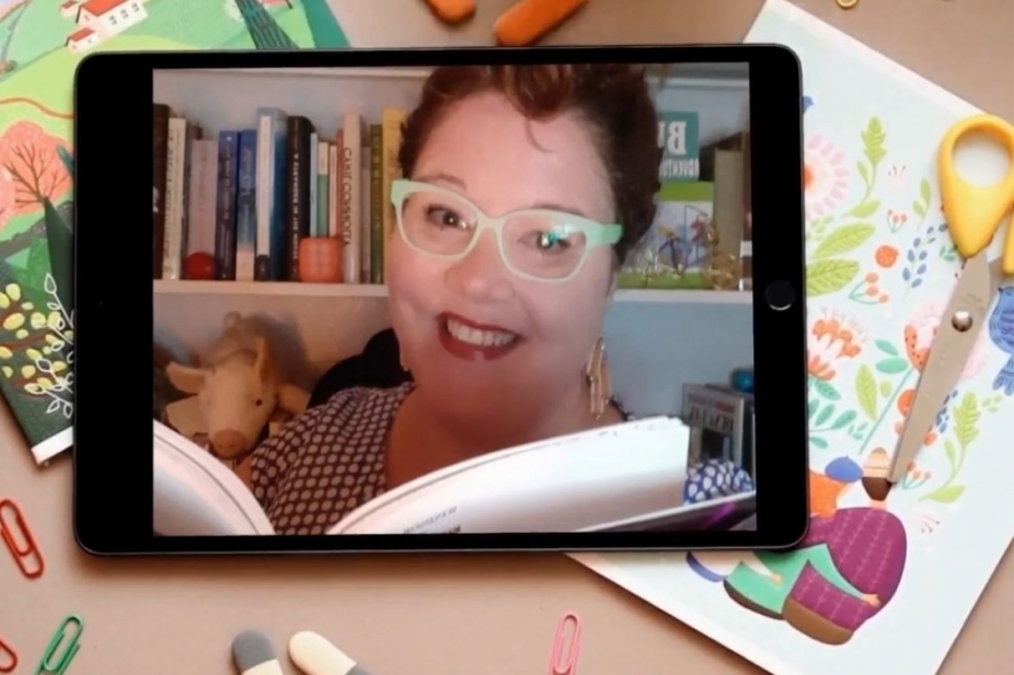 image of Kate Reynolds reading from a book and smiling superimposed on a tablet over some colourful drawings