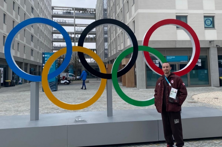 Anthony Pollock stands beside the Olympic rings statue in Milan.