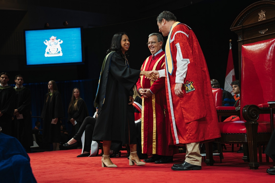 A graduating student is congratulated by Chancellor Dwight Duncan and President J.J. McMurtry.