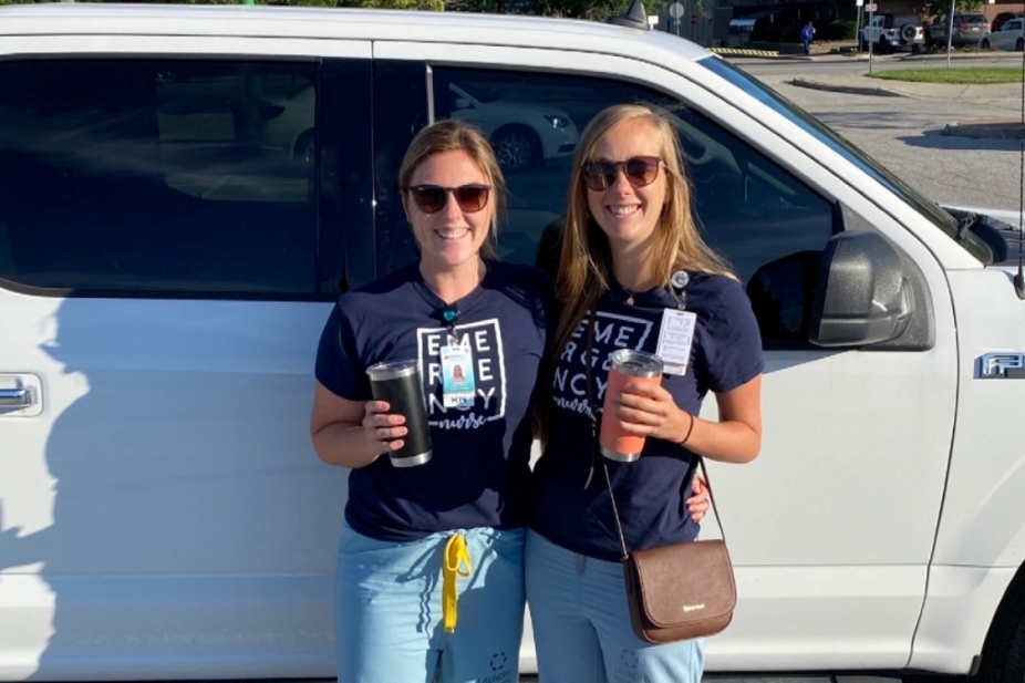 Destiny Cadarette stands beside a nursing colleague outside in front of a truck
