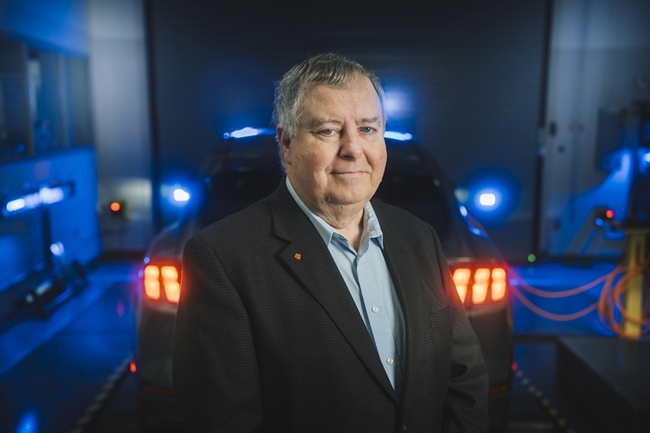 phot of Dr. Peter Frise in front of an electric vehicle