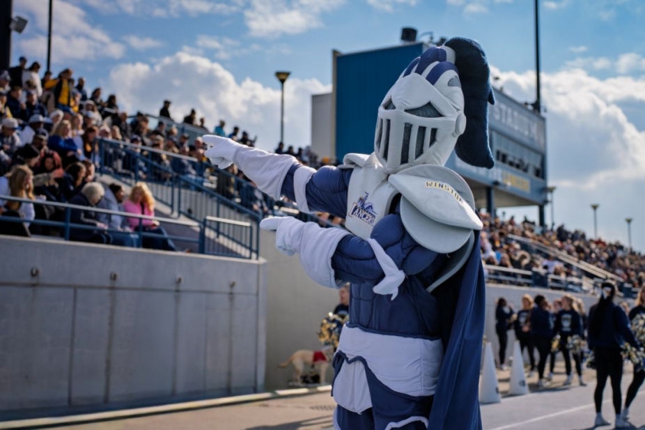 UWindsor Lancer mascot Winston in front of a crowd at a football game