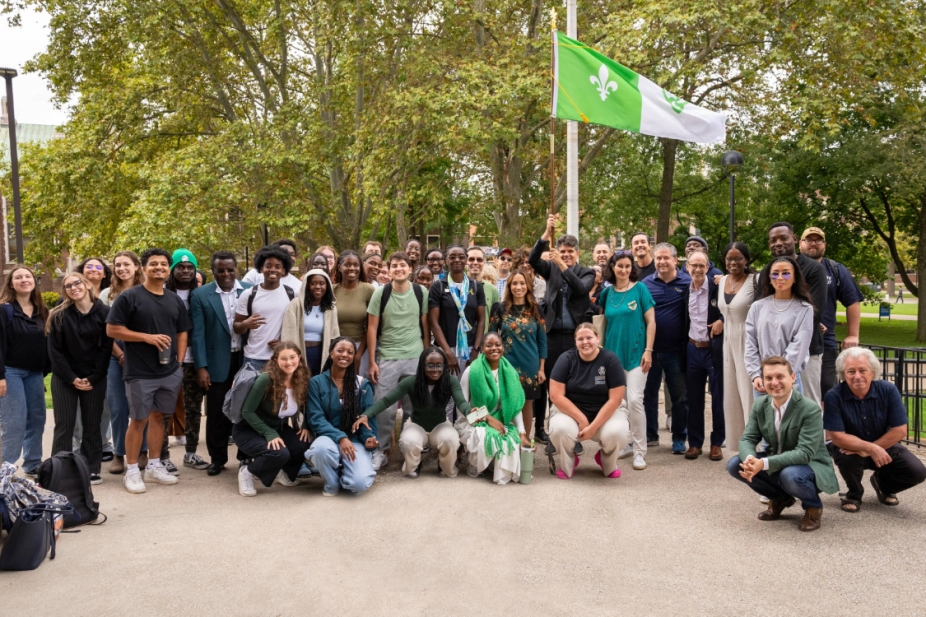 Students, faculty and staff stand outside for the Francophone flag raising