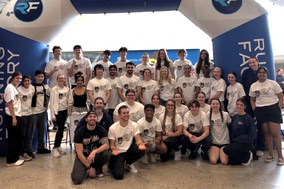 Group of students in front of inflatable running factory banner