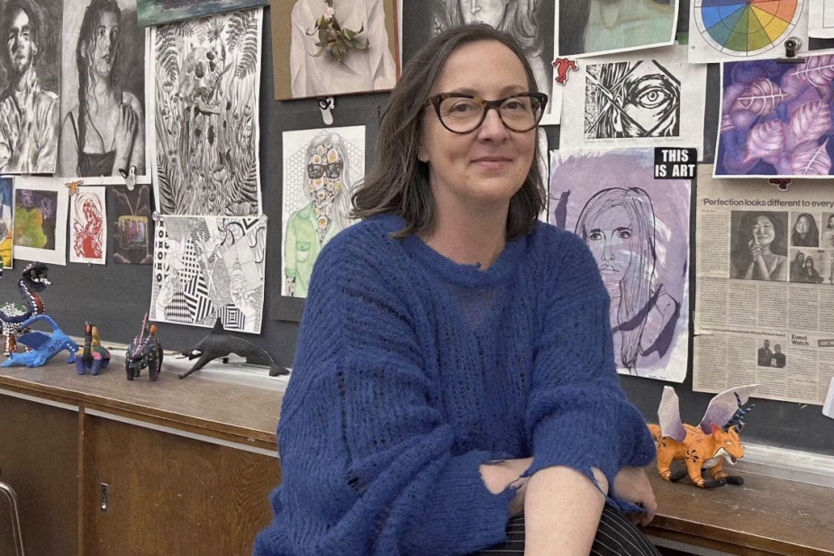 Sanja Srdanov in front of a wall of student art