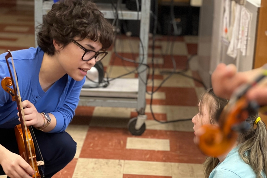 Avery Ng instructing with a violin