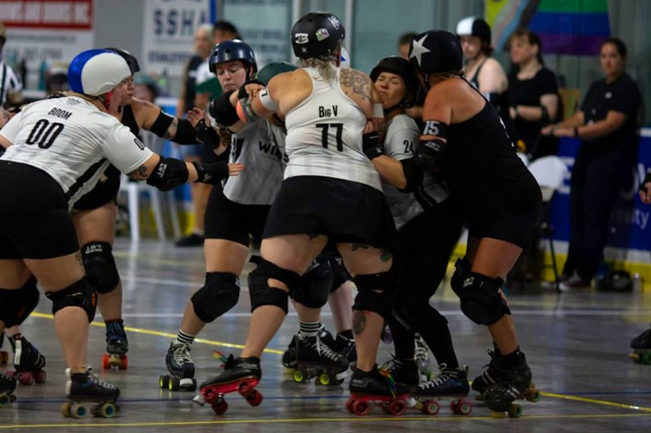 A wall of blockers in a roller derby game tries to stop their opponent