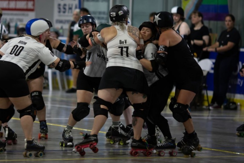 A wall of blockers in a roller derby game tries to stop their opponent