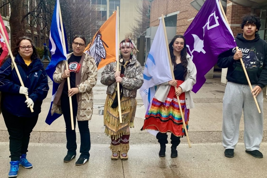Staff and students holding flags of Indigenous nations