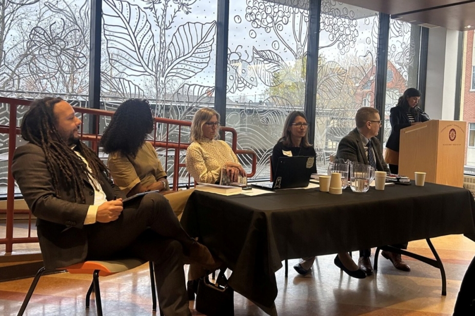Joshua Sealy-Harrington sits with his colleagues at the book launch.