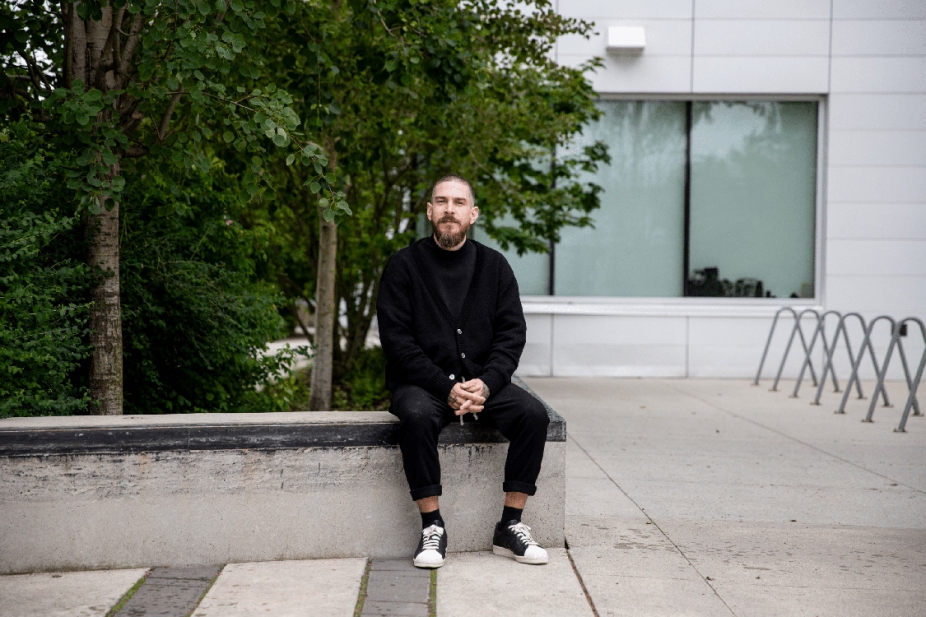 portrait of Justin Langlois seating in front of a building