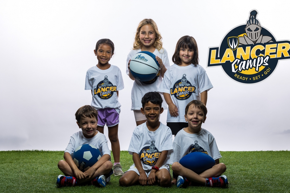 Children posing with lancer Camp t-shirts.