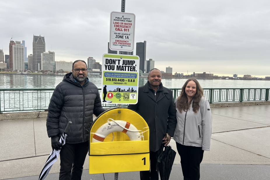 3 UWindsor members of the Lifeline Windsor Project team stand beside a new COMPASS station on Windsor's waterfront.