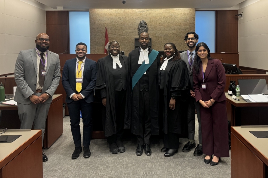 students and judges pose in the courtroom after a moot competition