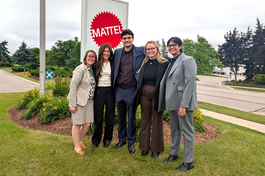 photo of MBA students standing beside Mattel Corporation sign