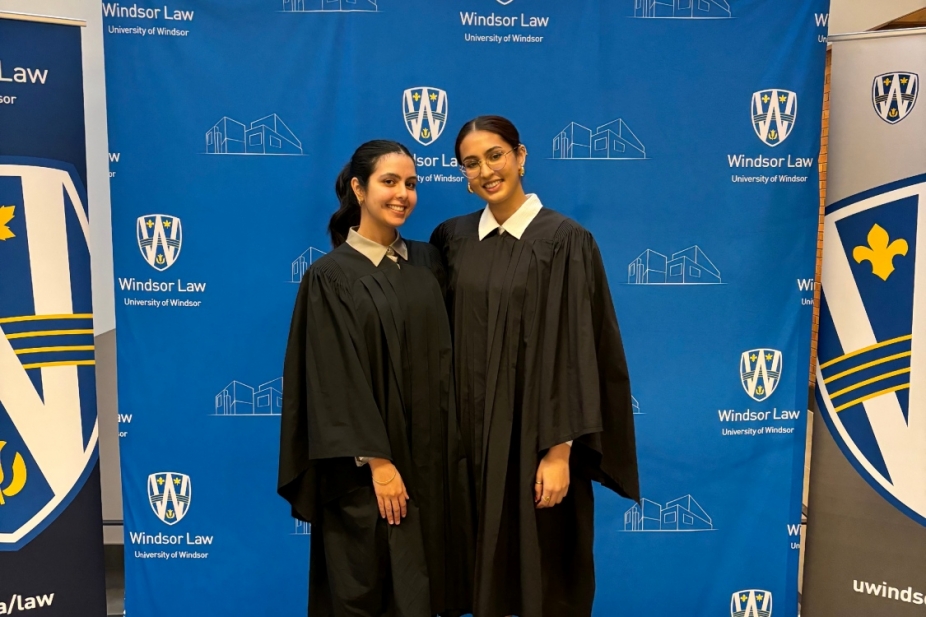 Jaskiran Braich stands with her classmate in front of a UWindsor sign.
