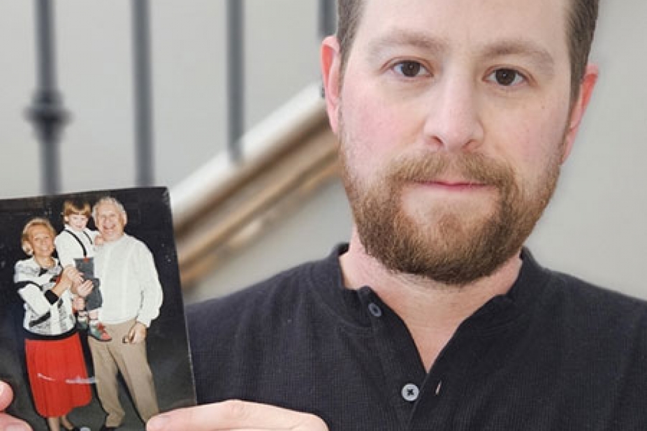 Dr. Kyle Brykman holds up a picture of his grandparents cradling him as a young boy