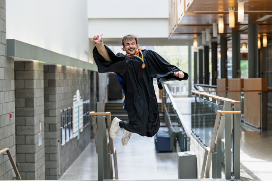Ethan jumps for joy in his graduation gown