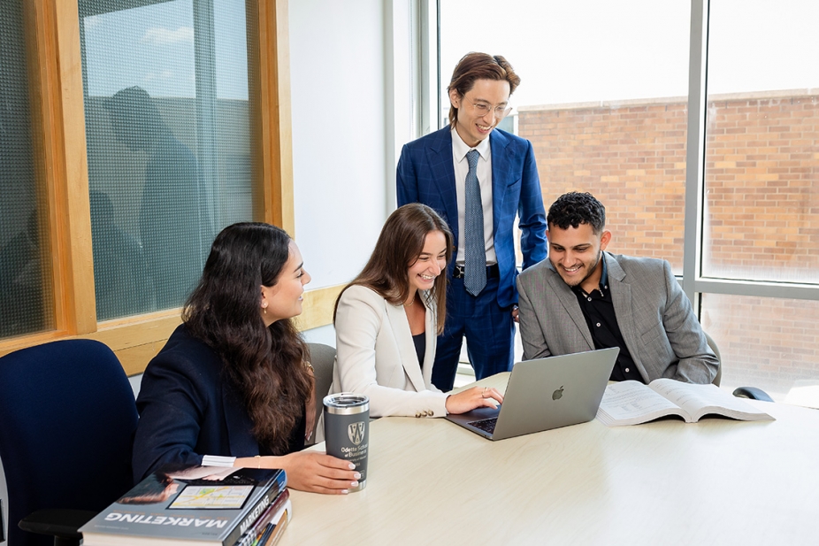 Odette business students seated around a computer