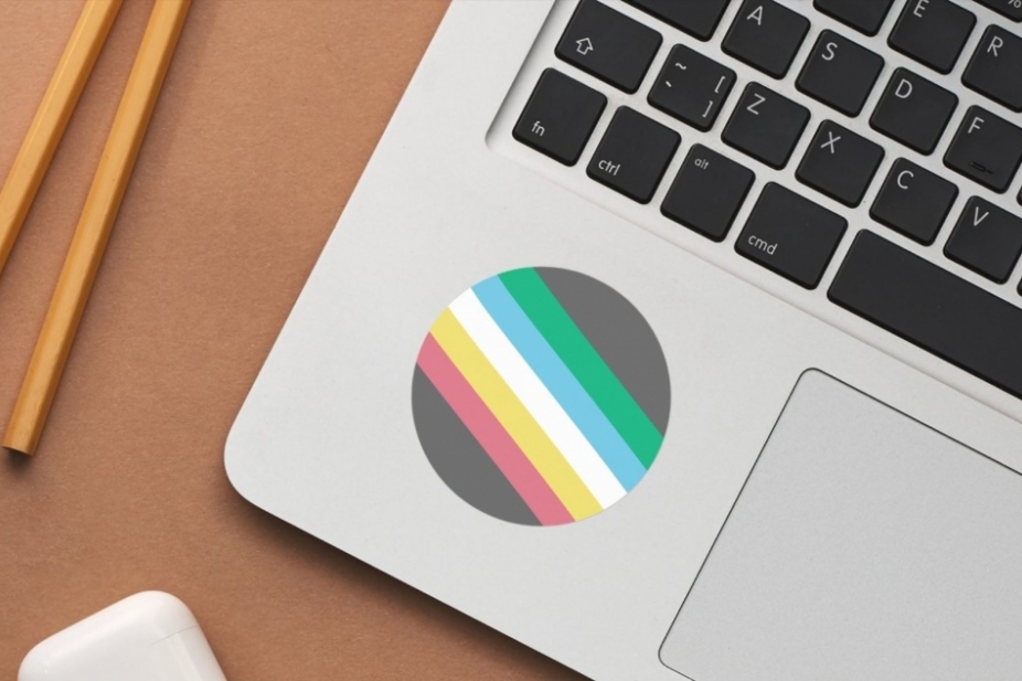 close up of disability pride flag sticker on a laptop