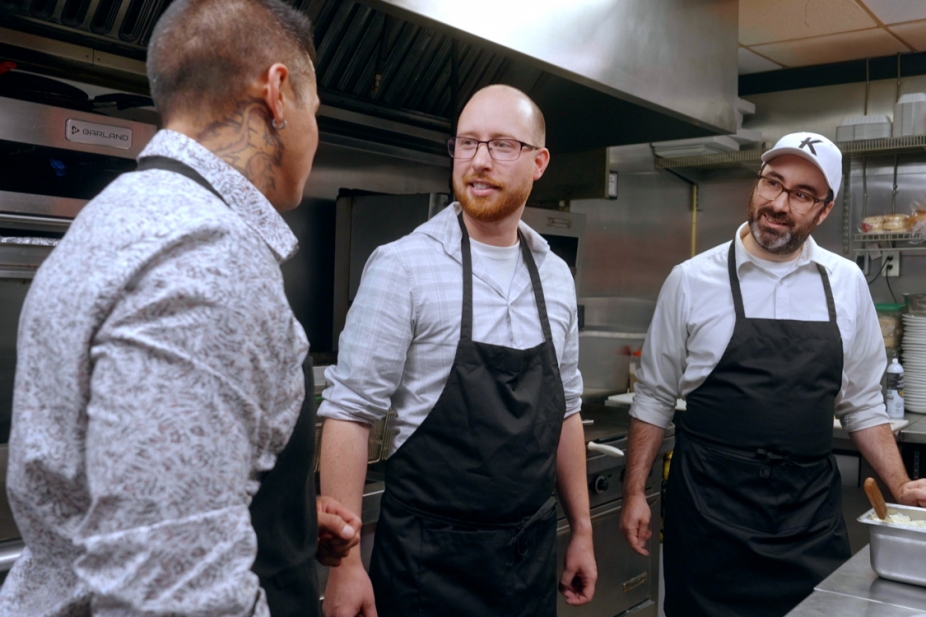 Producers and restaurant staff in a kitchen.