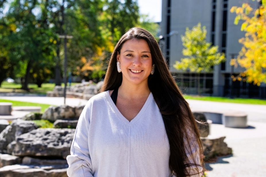 Professor Sara Williams stands outside on campus on a sunny day