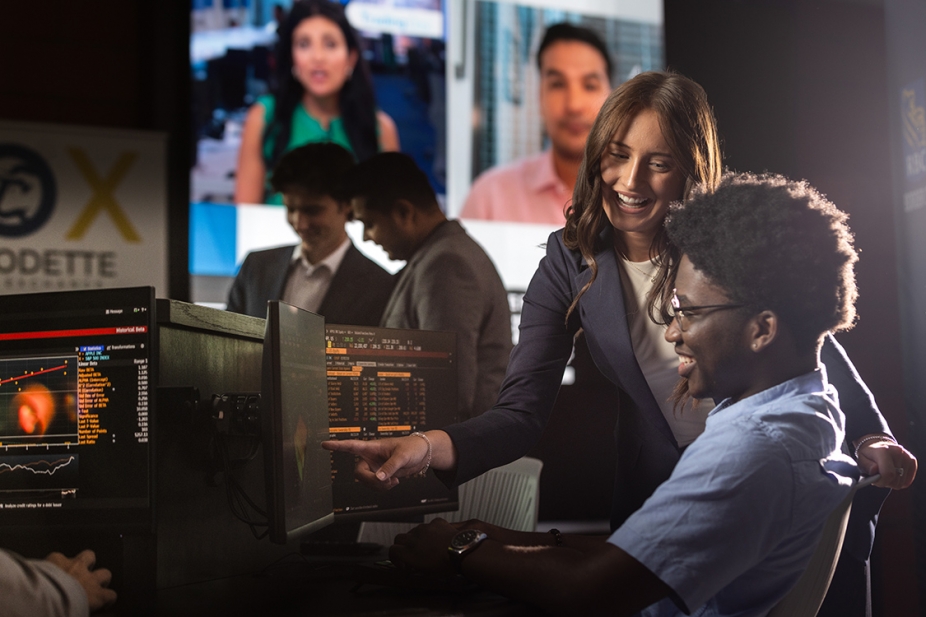 group of students sitting around computer in classroom