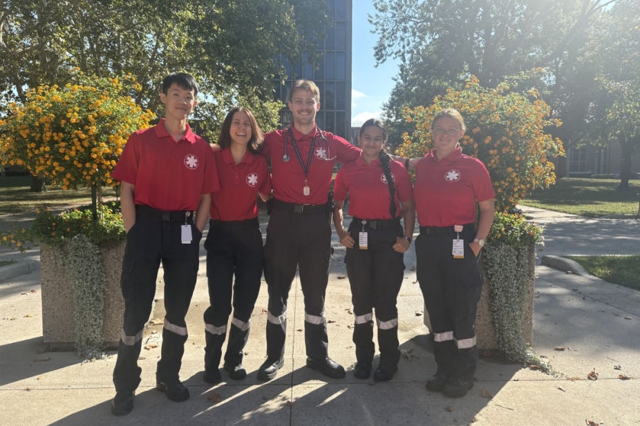 Student volunteers stand outside on campus wearing their SMRS uniforms