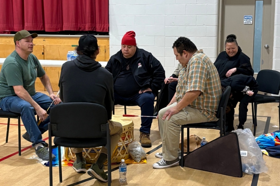 Members of Aamjiwnaang community gather around a traditional drum