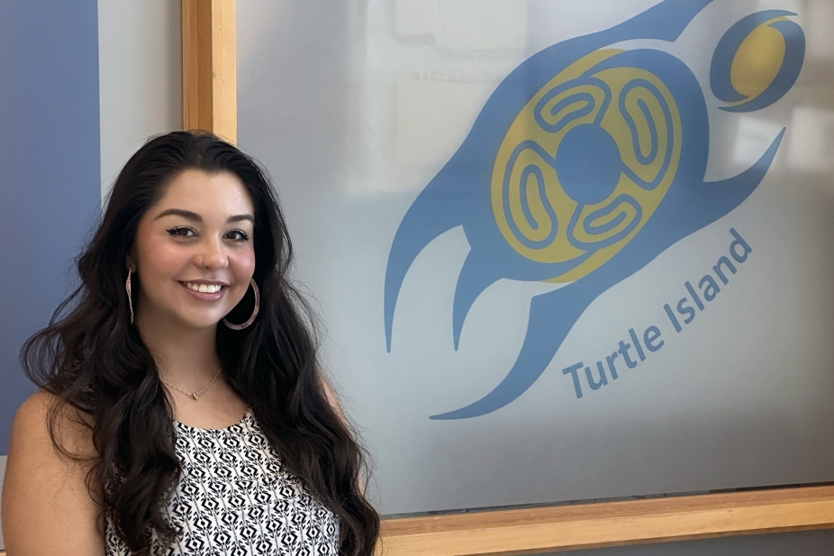 Victoria Hecnar, Turtle Island Event Planning and Communications Coordinator stands outside the newly renamed Turtle Island - Indigenous Student Services Centre