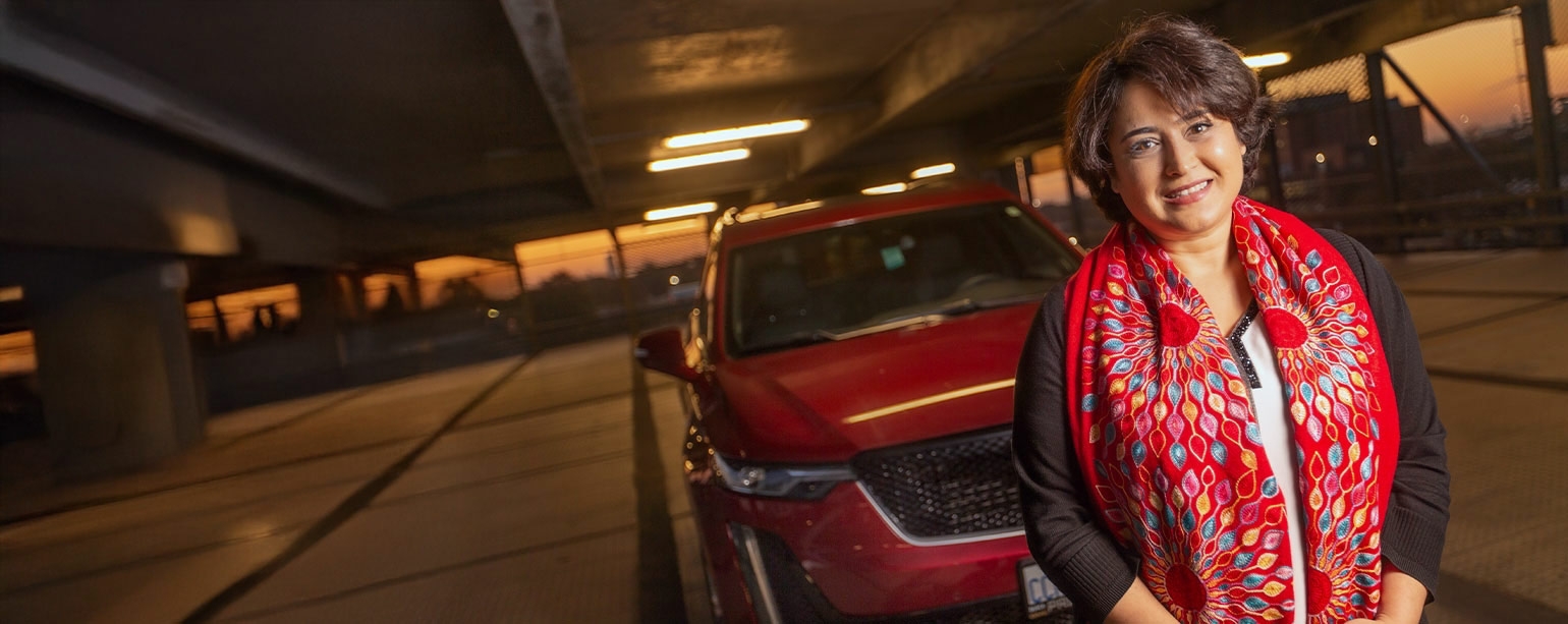 Mitra Mirhassani standing in front of a car in parking garage