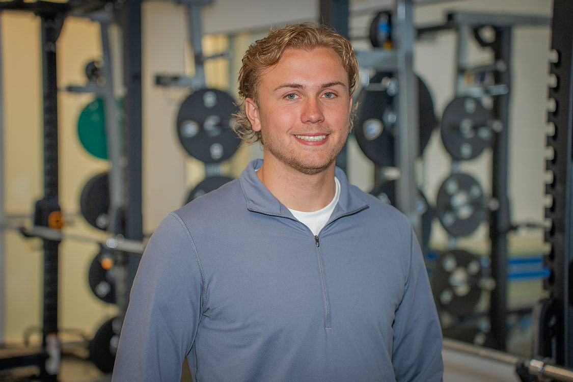 Brett Bjorgan in front of a rack of weights