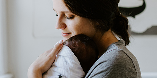 mom holding sleeping baby