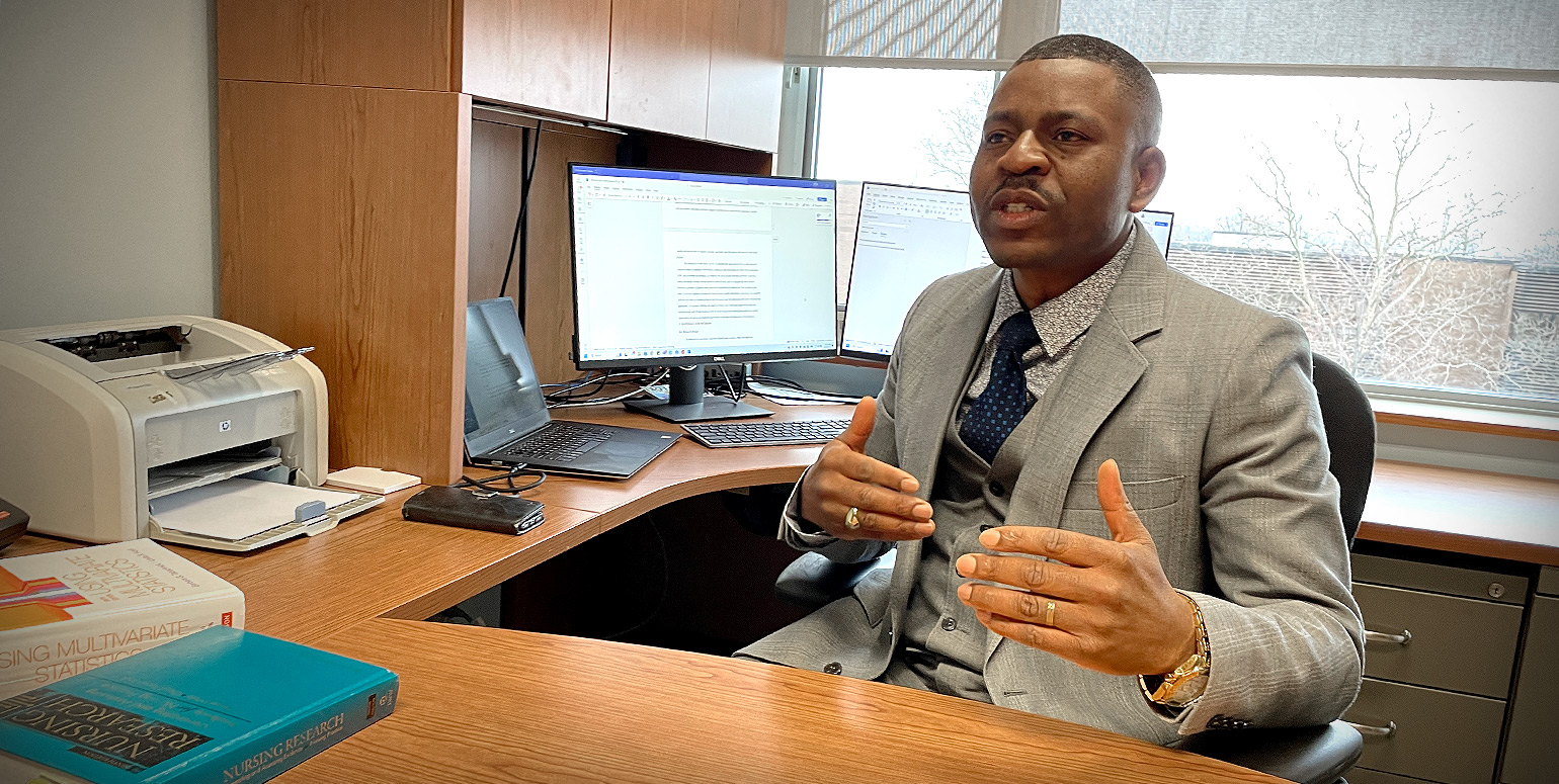 Dr. Eric Tanlaka at his office desk having a conversation