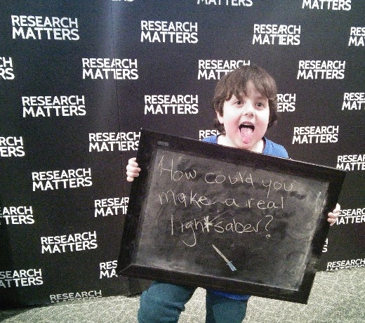 Young fan, James, holding up a board with a question