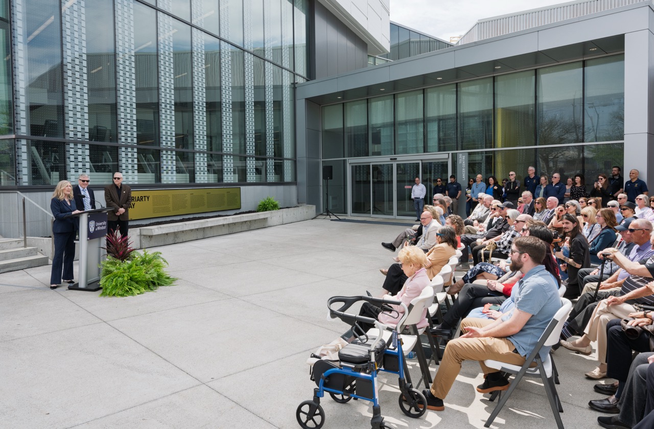 Katie Moriarty delivers remarks during the unveiling ceremony for Moriarty Way at the University of Windsor on April 22, 2026, joined by her brothers Sean and Dan Moriarty.