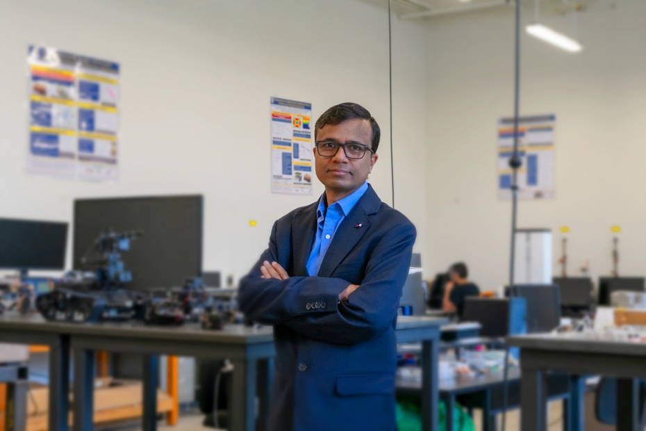Jalal Ahamed, an engineering professor at the University of Windsor, stands with arms crossed in a laboratory setting, surrounded by research equipment